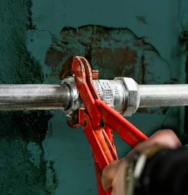 Klemmverbinder an einem Stahlrohr: Anziehen mit der Rohrzange