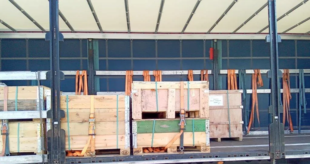 Umreifte Holzkisten auf Paletten mit Aufsatzrahmen im Lkw