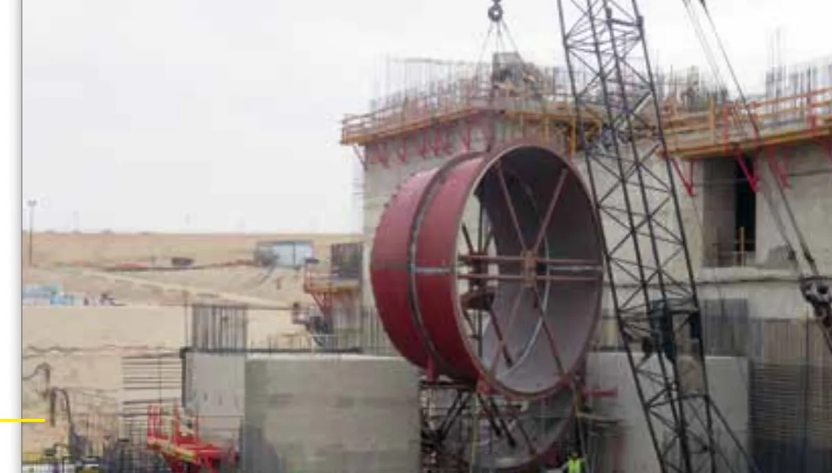 Baustelle eines Wasserkraftwerks mit Kran und Betonbau